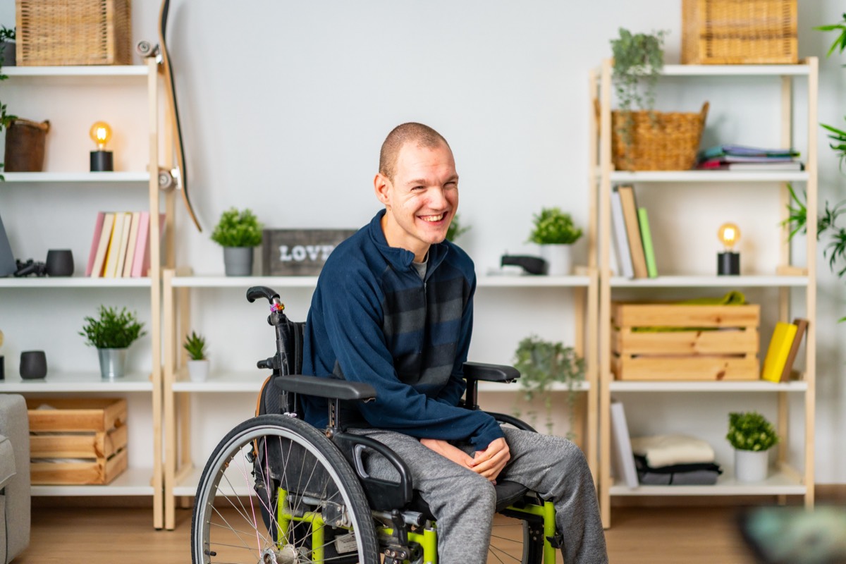 Person in a wheelchair smiling in front of an accessible home